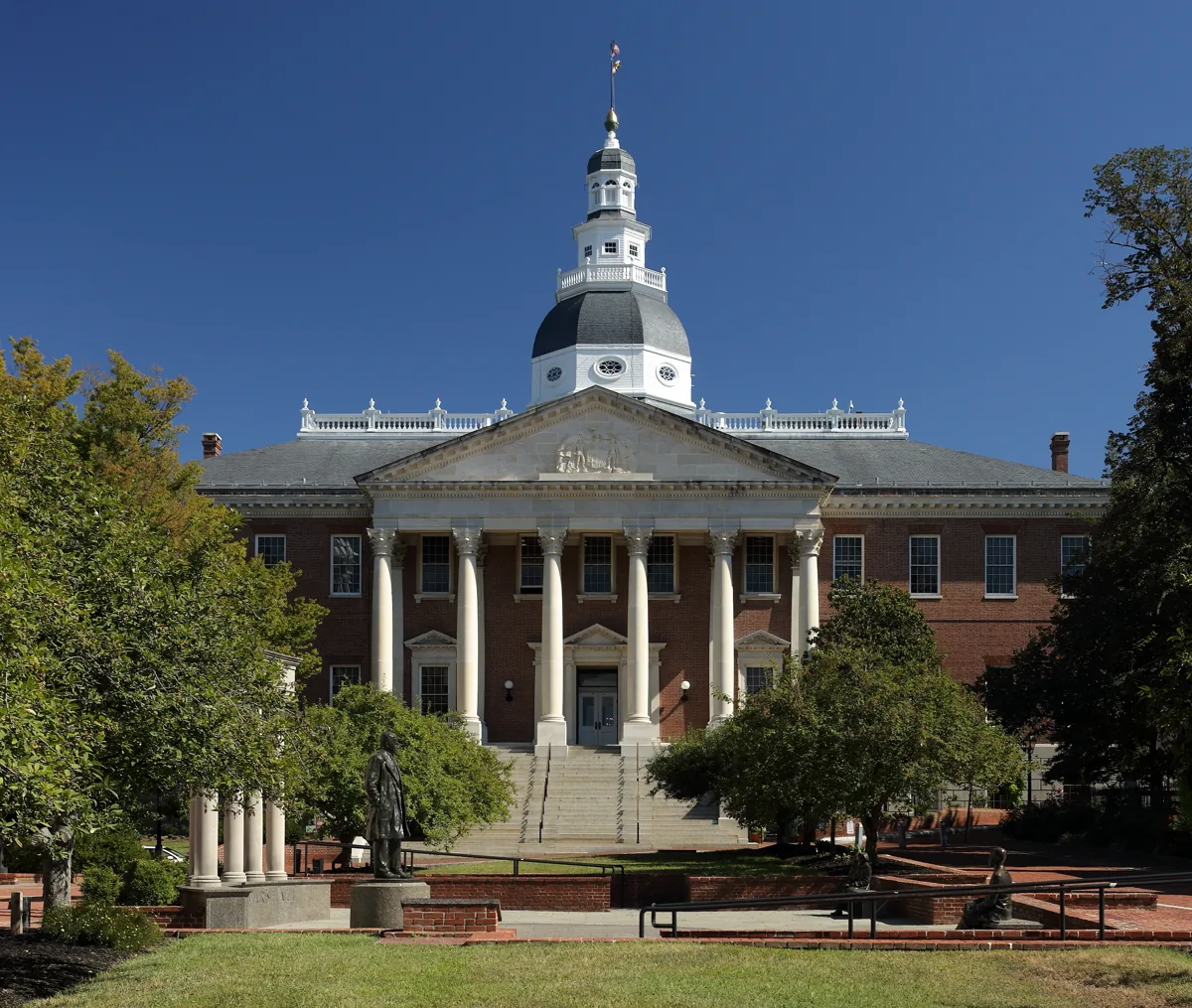 The Maryland State House with its white wooden dome and red-brick front seen from College Avenue