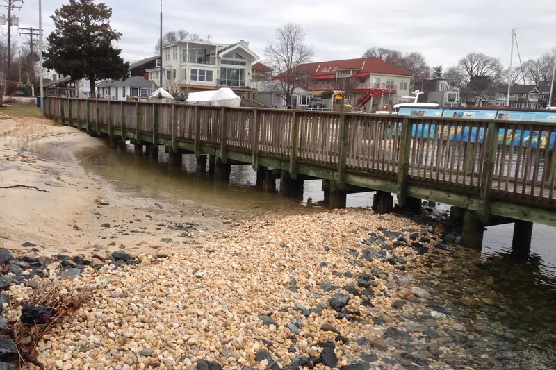 A wooden dock and pebble beach at the Annapolis Maritime Museum in Eastport