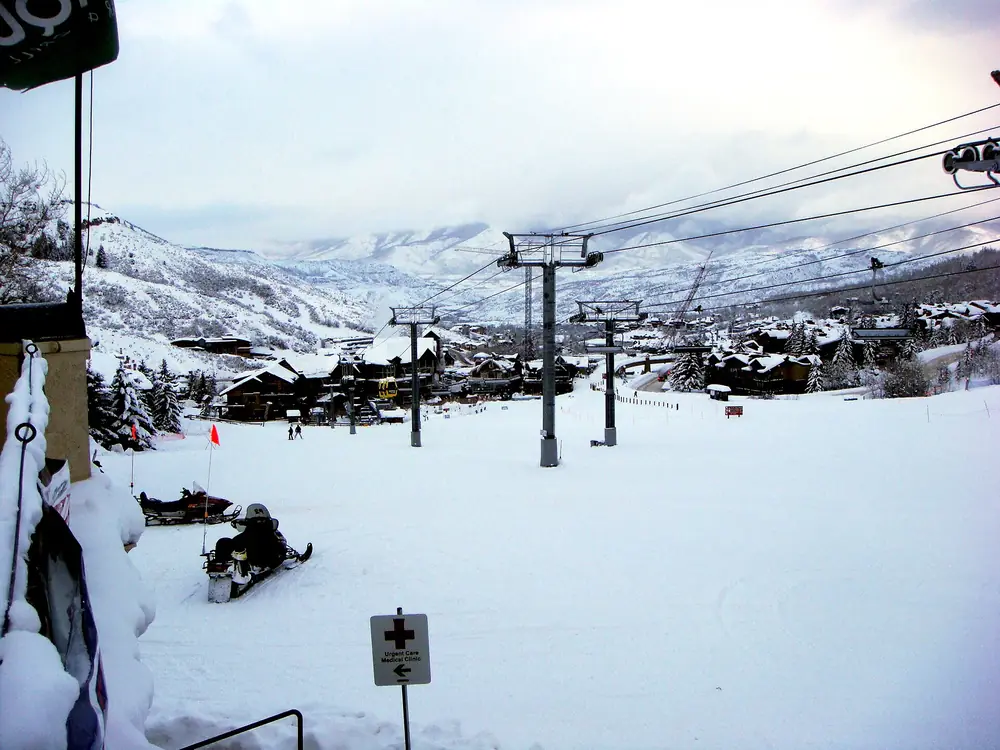 Snow-covered base village with chairlifts at dusk