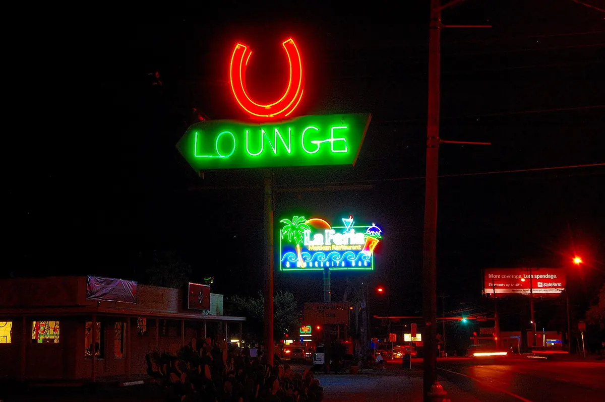 The Horseshoe Lounge neon sign at night in Austin
