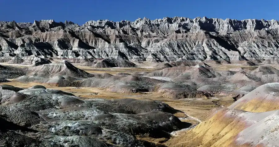 Badlands formations under a hard blue sky