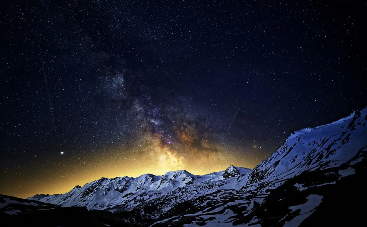 The Milky Way over snowy mountain peaks