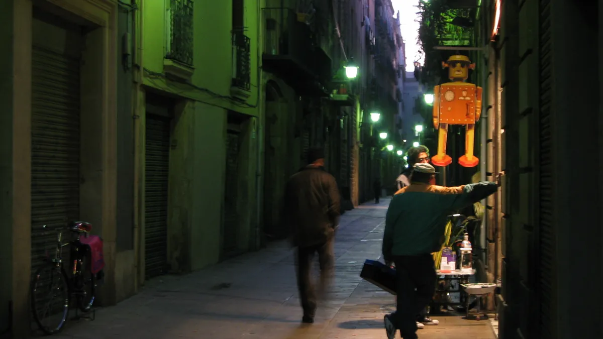 A lane of the Barri Gòtic in Barcelona at night under street lamps