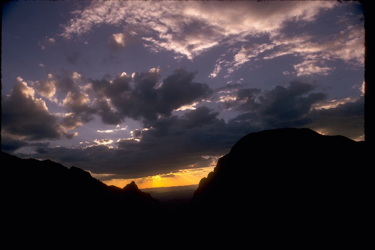 Dramatic clouds and a last band of sunset light over the Chisos Basin skyline
