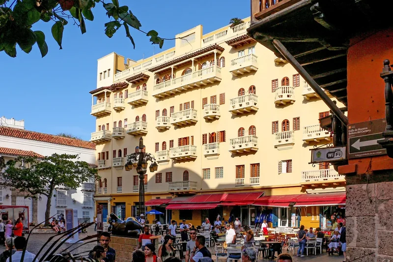 Yellow colonial buildings with balconies and café tables on Plaza de Santo Domingo