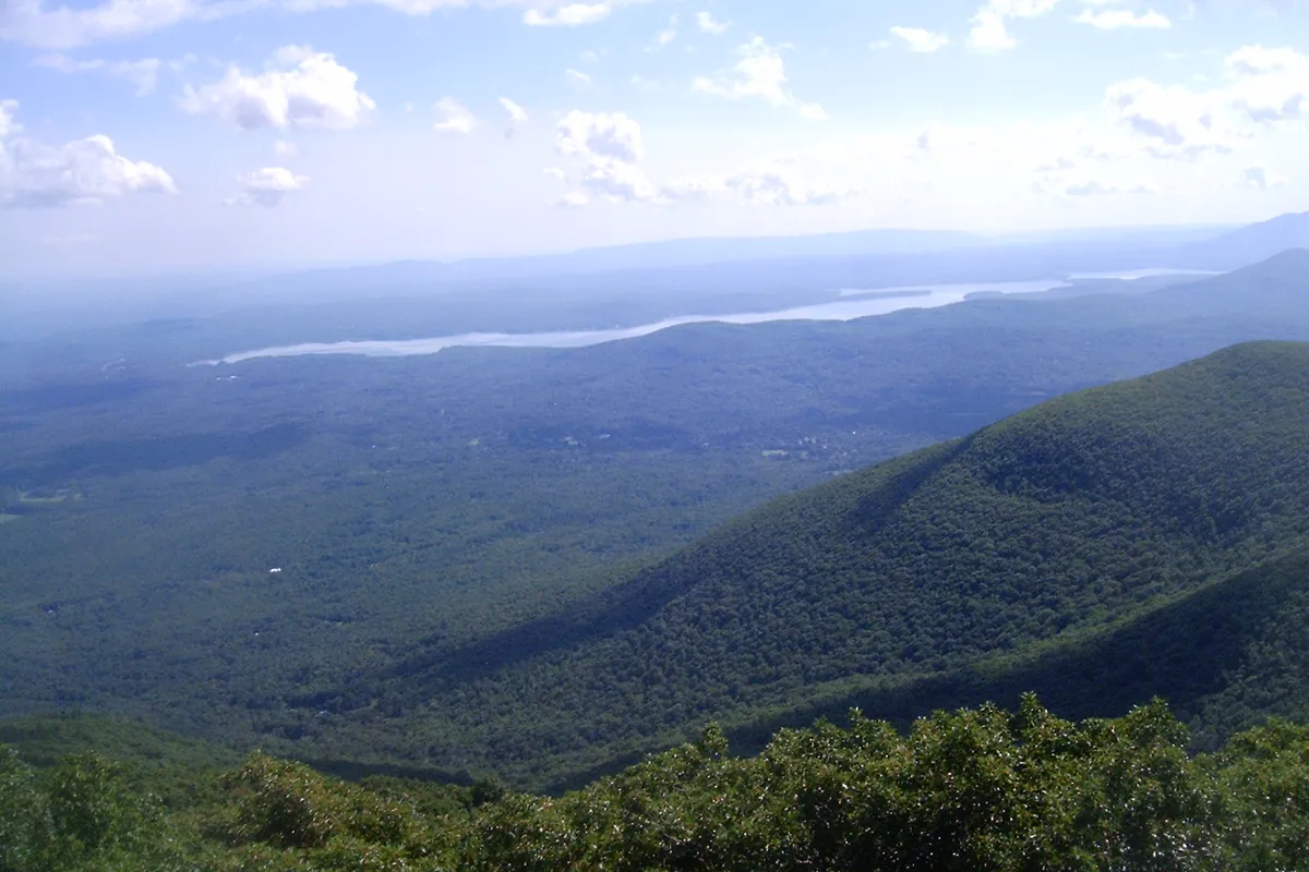 The view from the Overlook Mountain fire tower over forested ridges to a distant reservoir