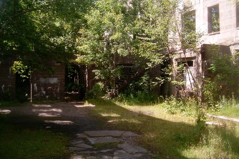The roofless concrete ruins of the Overlook Mountain House among trees