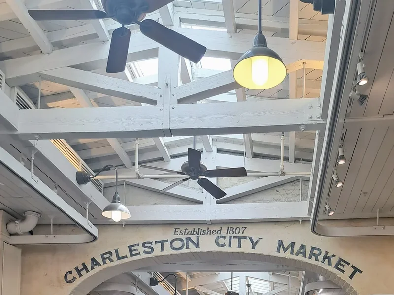 Inside the Charleston City Market, a long covered shed with wooden rafters over rows of stalls