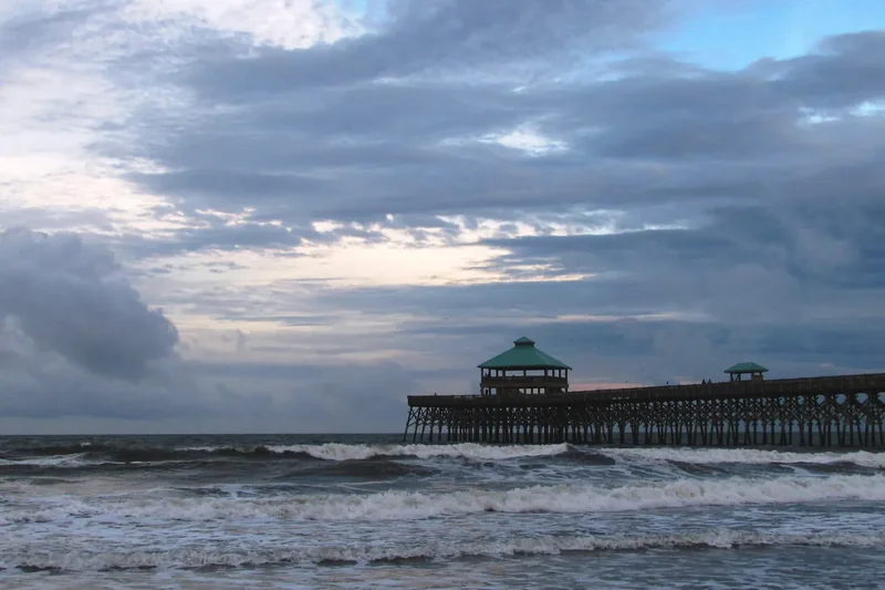 The long fishing pier at Folly Beach reaching out over the surf on a clear day