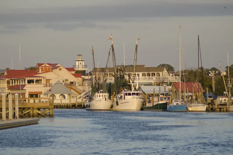 Shem Creek at dusk with boats and waterfront docks under a fading sky