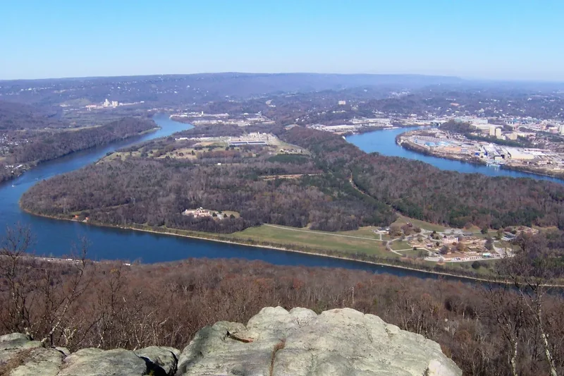The Tennessee River curving around Moccasin Bend, seen from a rocky ledge on Lookout Mountain with Chattanooga beyond