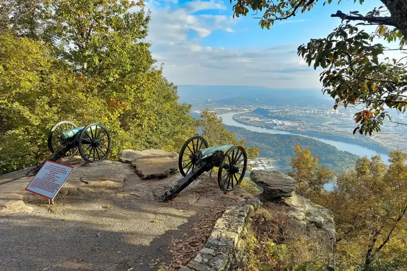 Two Civil War cannons on a rocky bluff at Point Park, with autumn trees and the Tennessee River valley below