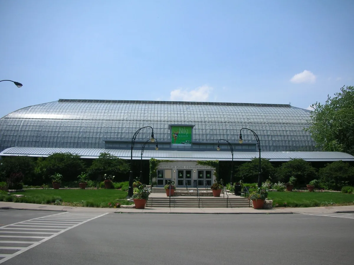 The glass and steel structure of the Garfield Park Conservatory with palms inside