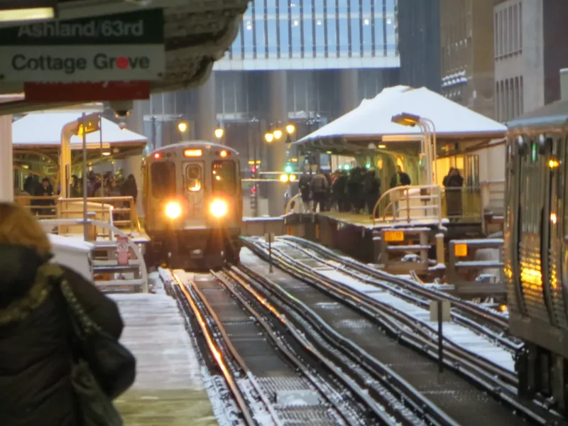 A CTA elevated train arriving at a snowy Loop platform at Randolph and Wabash