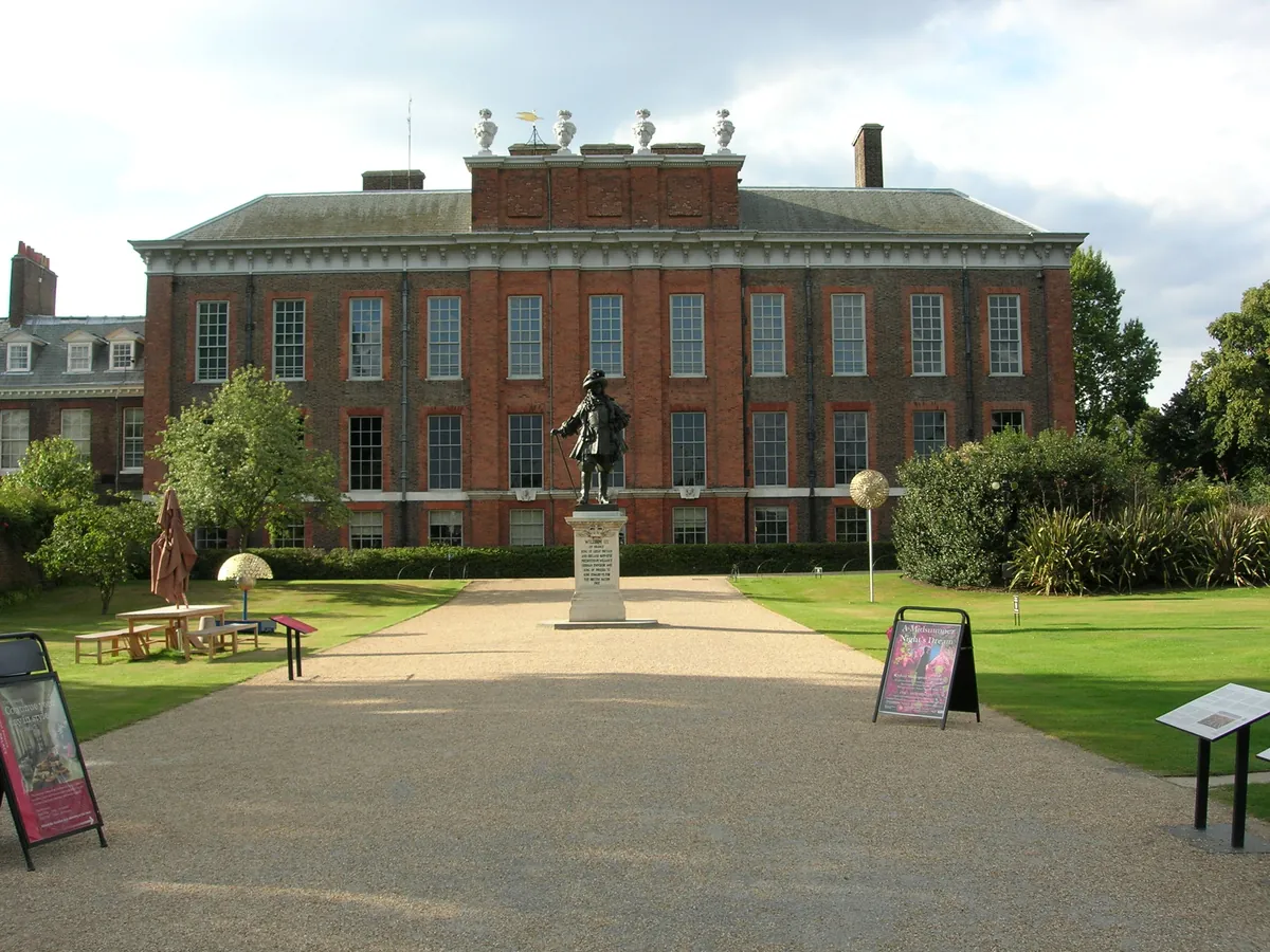 Kensington Palace, a red-brick palace with a statue in front and a path across the lawn