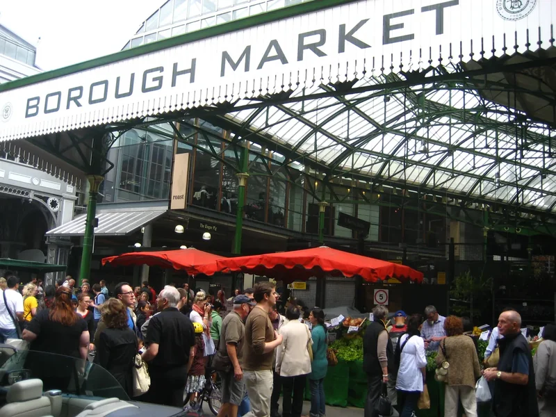 Crowds under the Borough Market sign and glass roof by London Bridge