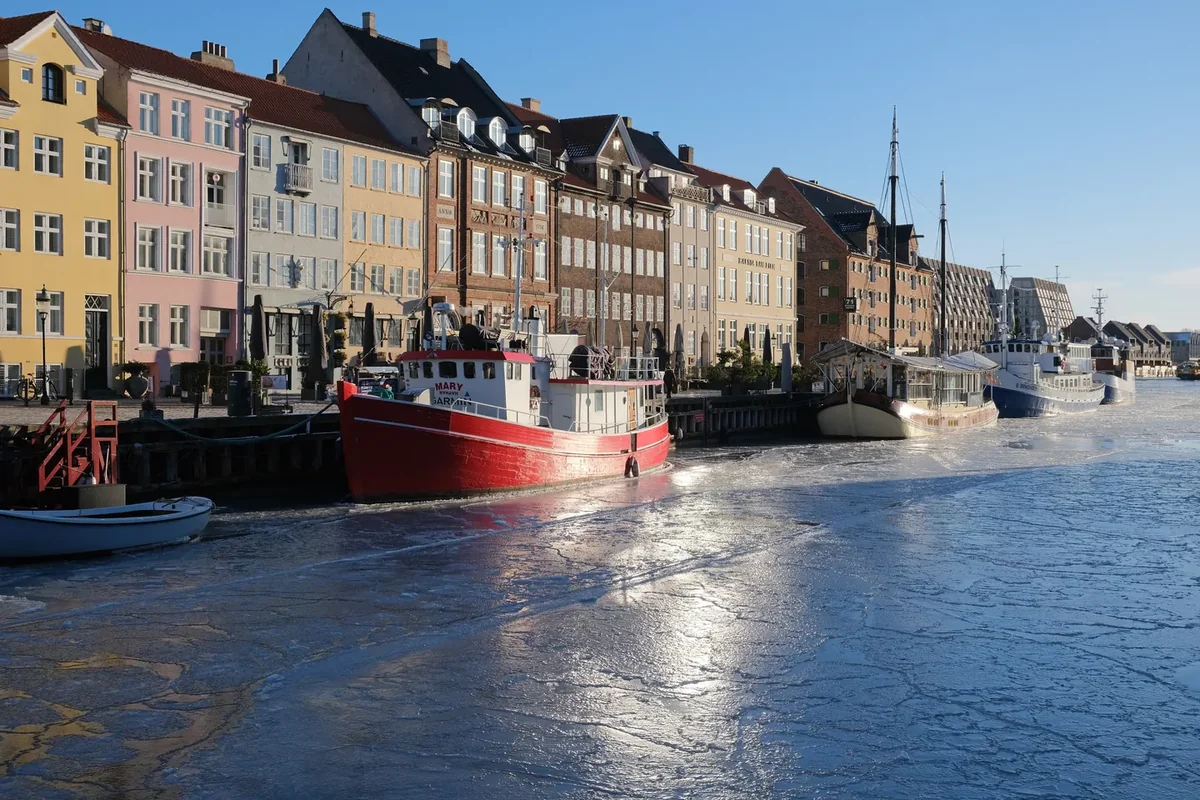 Nyhavn in winter, the coloured gabled houses along the canal with old wooden boats moored in front