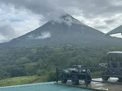Arenal Volcano’s cone wrapped in cloud above the forest