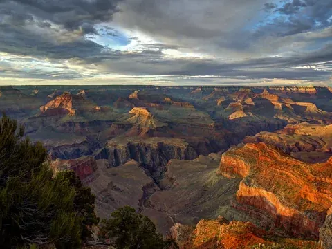 Late light on the layered buttes below Hopi Point under a cloudy sky