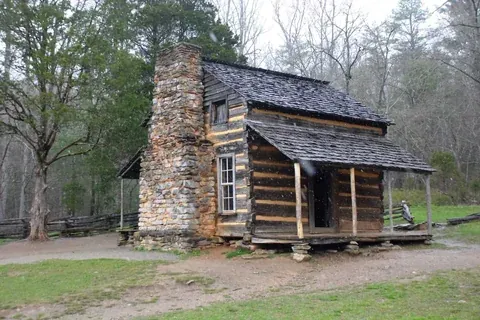The John Oliver Cabin, a weathered log cabin in a grassy clearing at Cades Cove