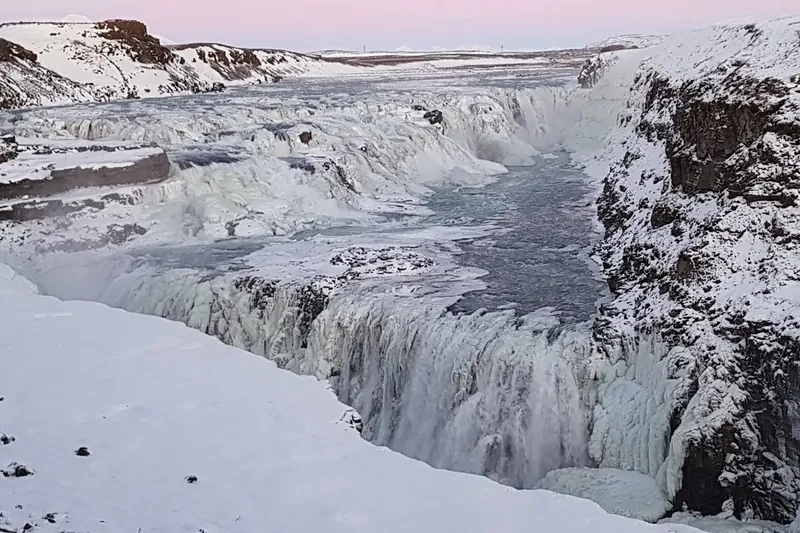 Gullfoss waterfall pouring into a snowy canyon in winter
