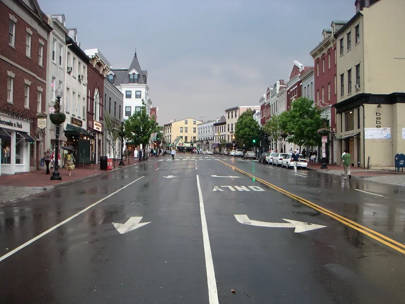 Wisconsin Avenue in Georgetown on a rainy day, with shopfronts and the wet street
