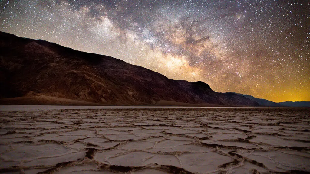 Milky Way arching over the salt polygons of Badwater Basin at night