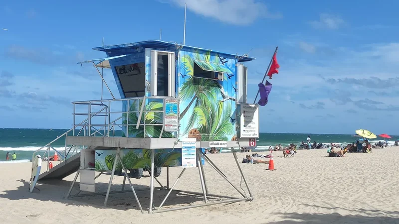 A brightly coloured lifeguard tower on the sand at Fort Lauderdale Beach