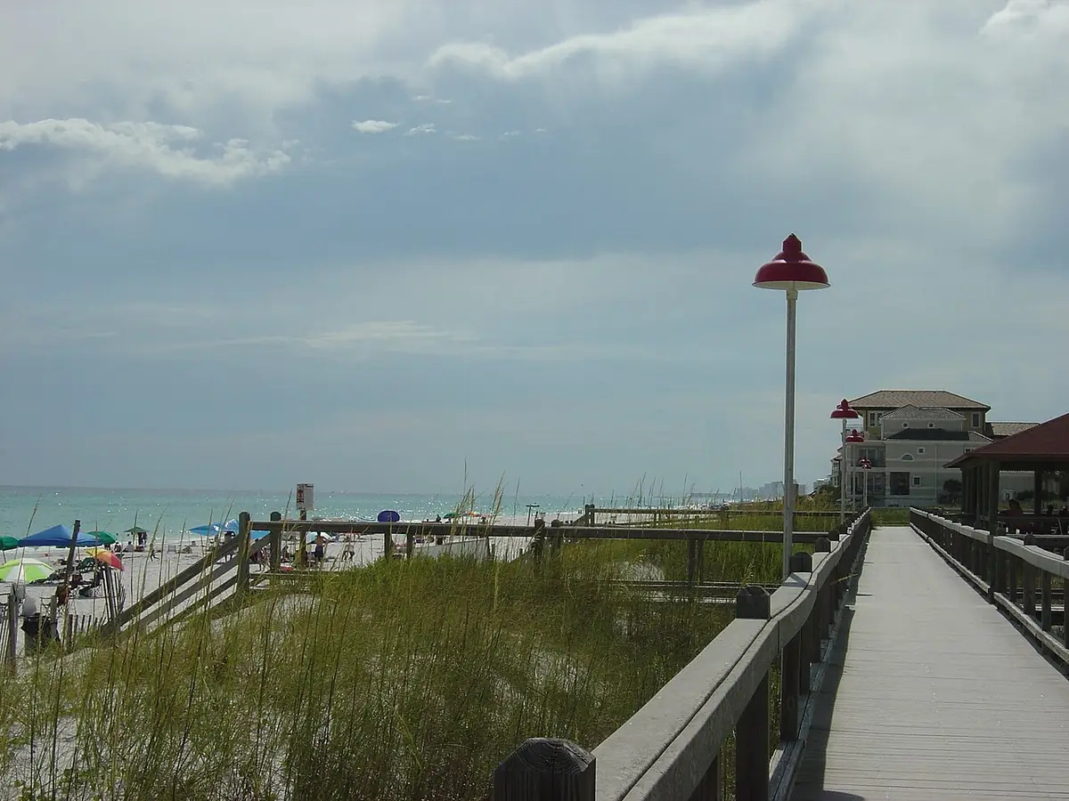Boardwalk over the dunes to the beach on Okaloosa Island, umbrellas on the sand