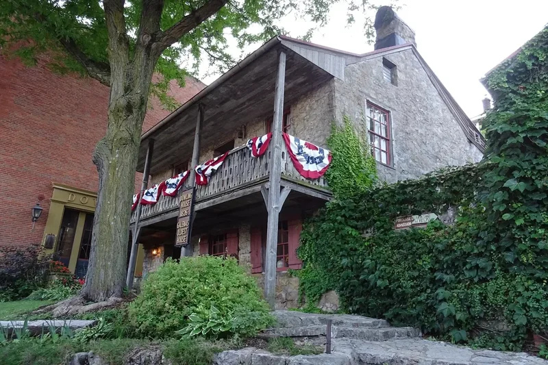 The Dowling House in Galena, a stone house with a wooden balcony and bunting on a terraced slope