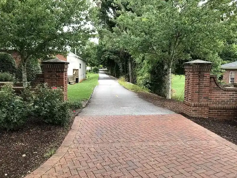 The paved Swamp Rabbit Trail between brick gateposts