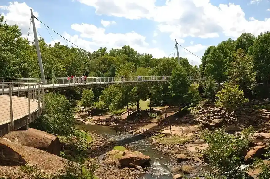 The Liberty Bridge curving over Reedy River Falls in Falls Park