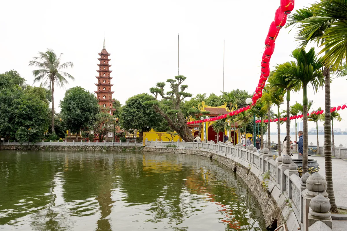 The tall red stupa of Tran Quoc Pagoda beside West Lake in Hanoi