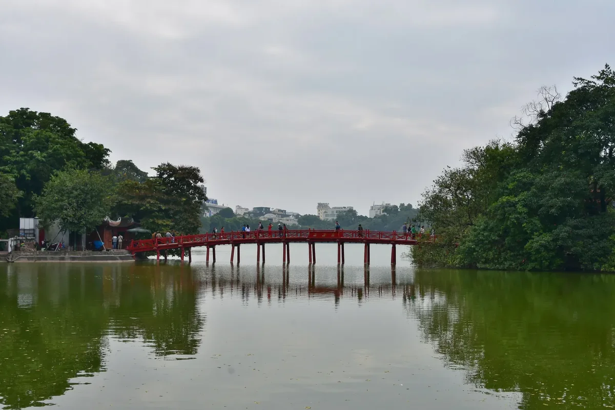 The red The Huc bridge crossing Hoan Kiem Lake to Ngoc Son Temple in Hanoi