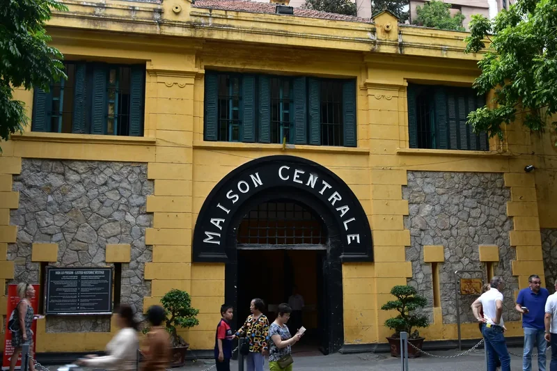 The yellow gate of Hoa Lo Prison in Hanoi with the words Maison Centrale