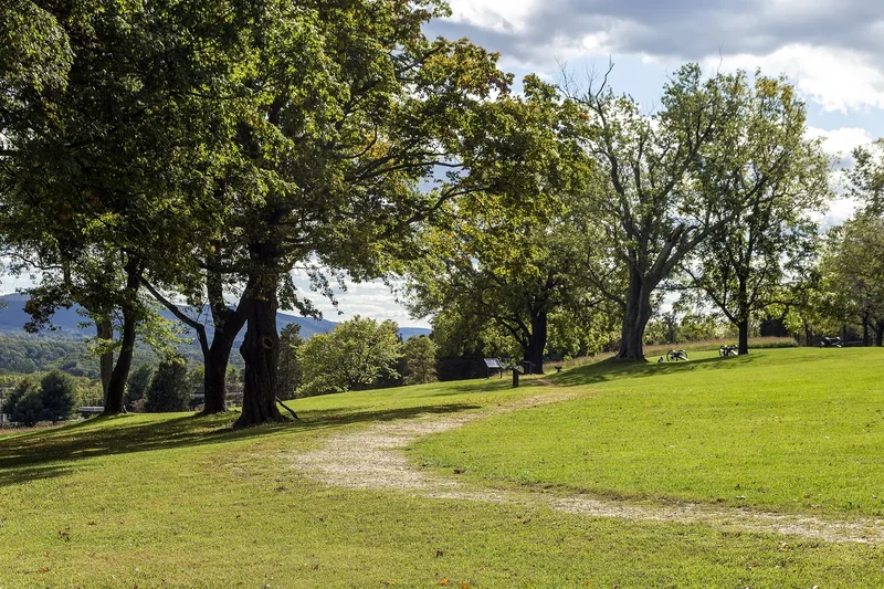 A grassy ridge with large trees and a gravel path on Bolivar Heights above Harpers Ferry