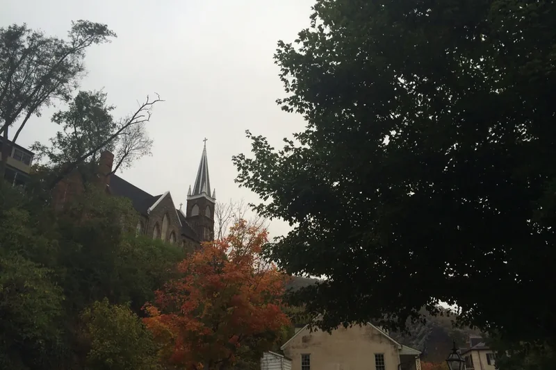 Autumn trees in orange and gold along a street of old buildings in Lower Town Harpers Ferry