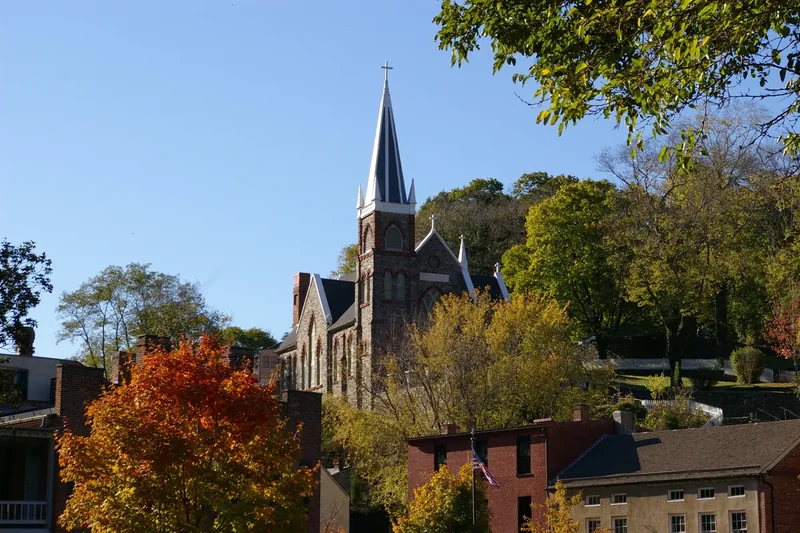 St. Peter’s Catholic Church with its tall spire above Lower Town rooftops and autumn trees