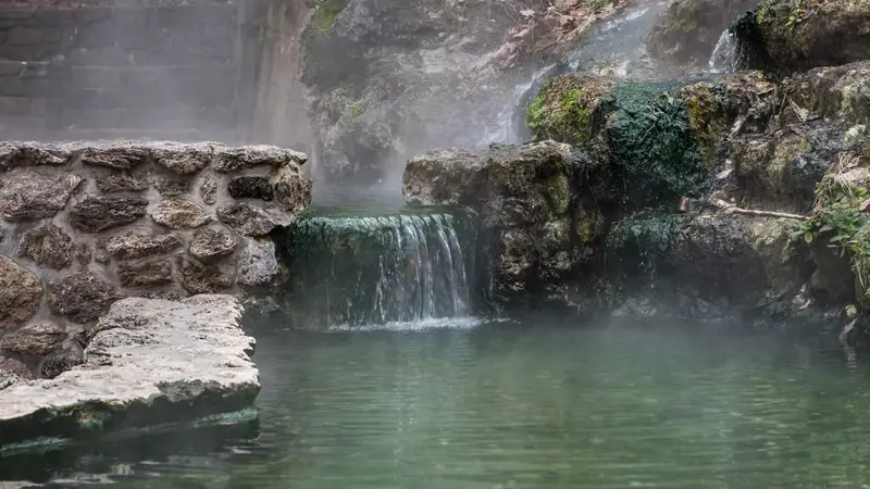 Steaming thermal spring water cascading over rocks in Hot Springs National Park