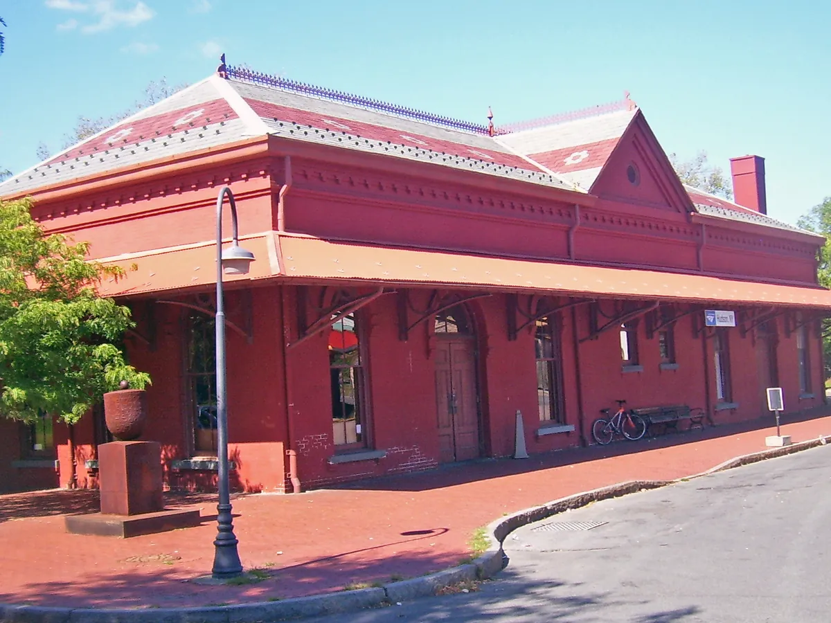 The red brick Hudson train station with a deep overhanging roof and a curved drive in front