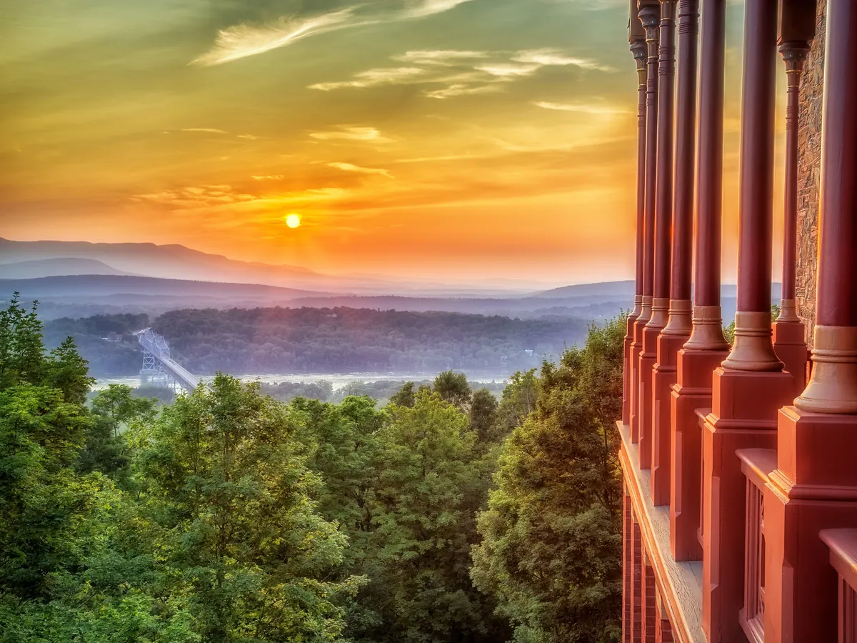 Sunset over the Hudson River and the Catskill Mountains seen from the porch of Olana, with the Rip Van Winkle Bridge below