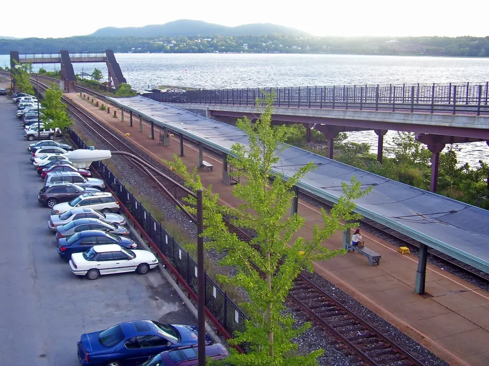 The platform at Rhinecliff station beside the tracks, with the Hudson River and a footbridge behind