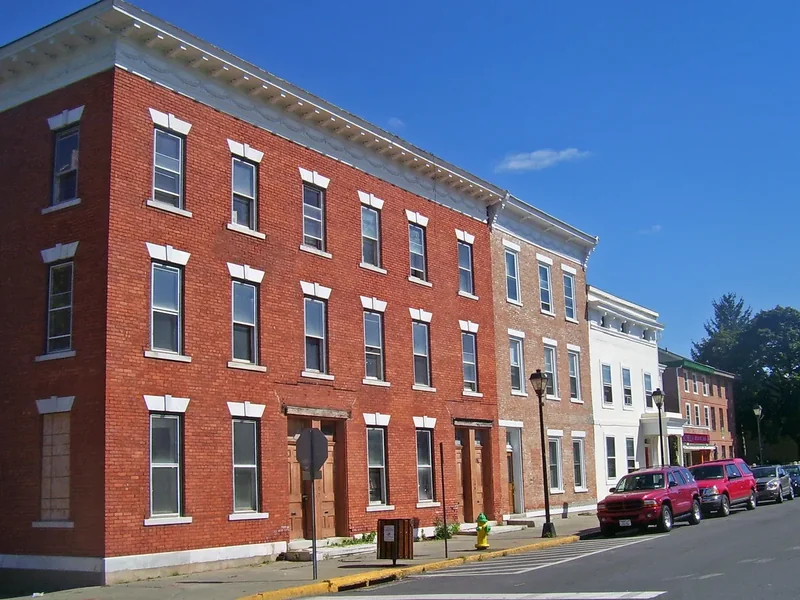 A row of red-brick buildings on Lower Warren Street in Hudson, with shopfronts at street level