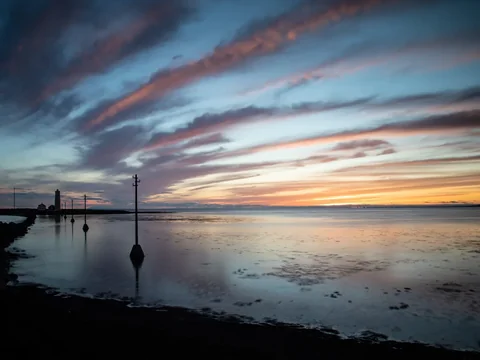 Grótta lighthouse silhouetted against a pink and blue sky after sunset