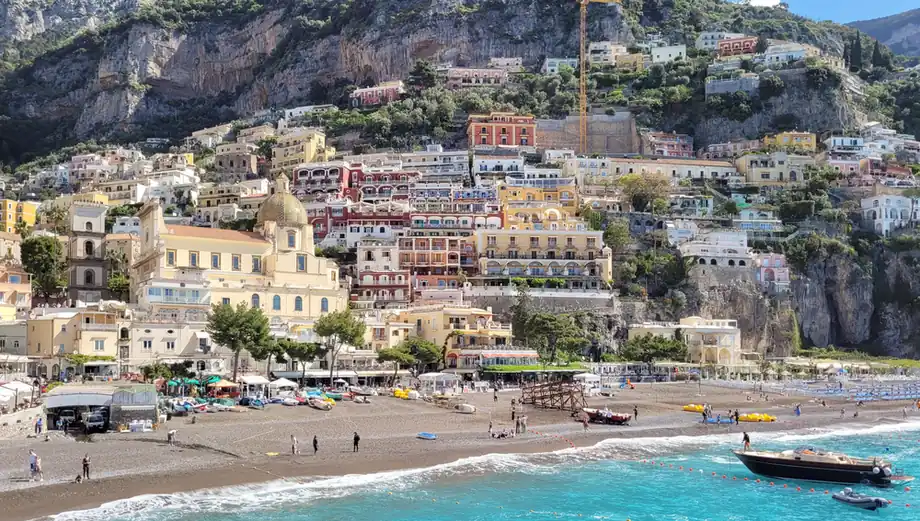 Positano's pastel houses cascading to the sea, seen from the water