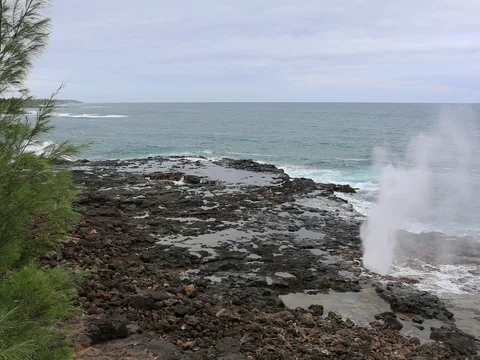Spray bursting up from the lava shelf at Spouting Horn on Kauai’s south shore