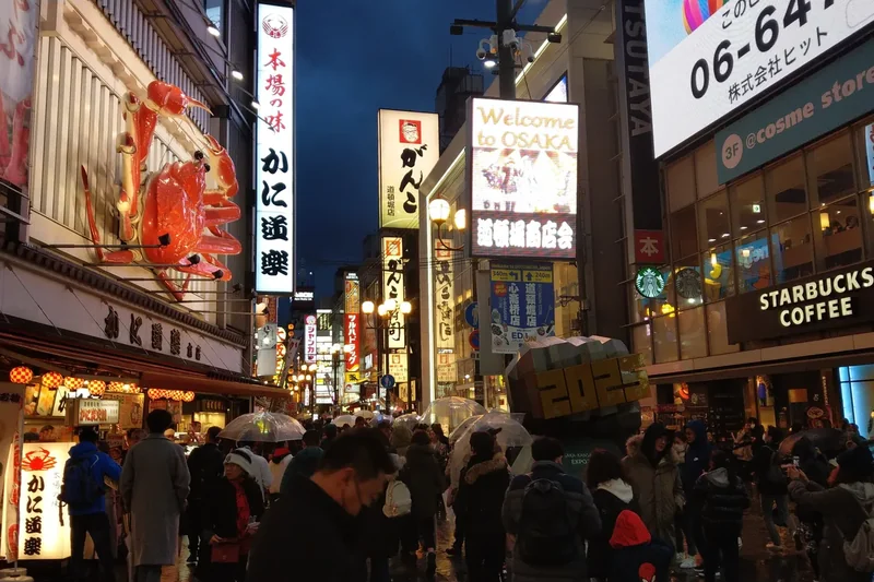 The Dotonbori canal in Osaka at night with lit building fronts reflected in the water