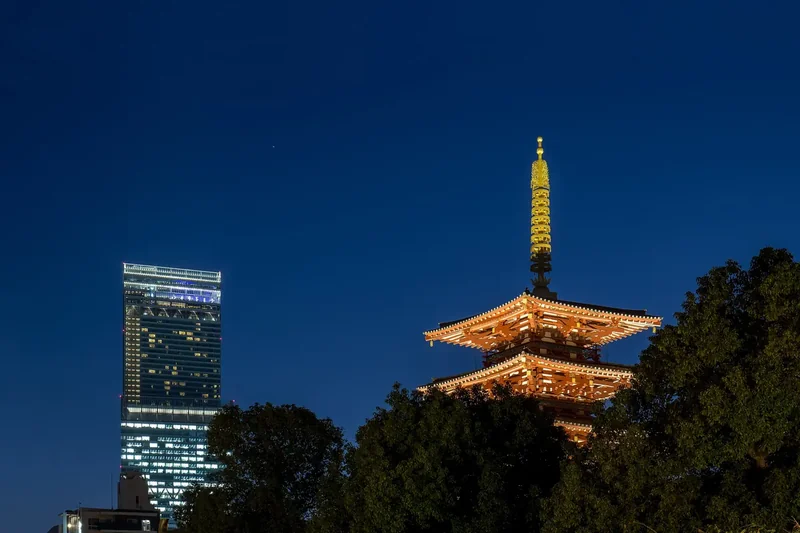 The five-storey pagoda of Shitennoji at dusk with the Abeno Harukas tower behind