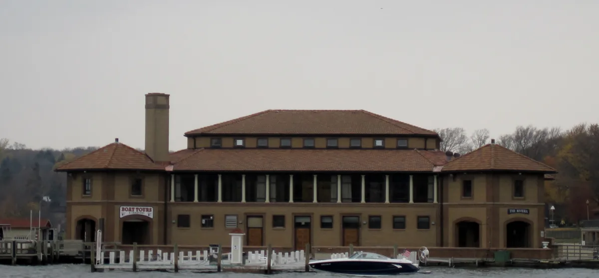 The Riviera pavilion on the Lake Geneva lakefront, a long building with a tile roof seen from the water