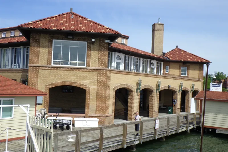 The Riviera’s tan brick front and arched windows with a wooden deck on the lake
